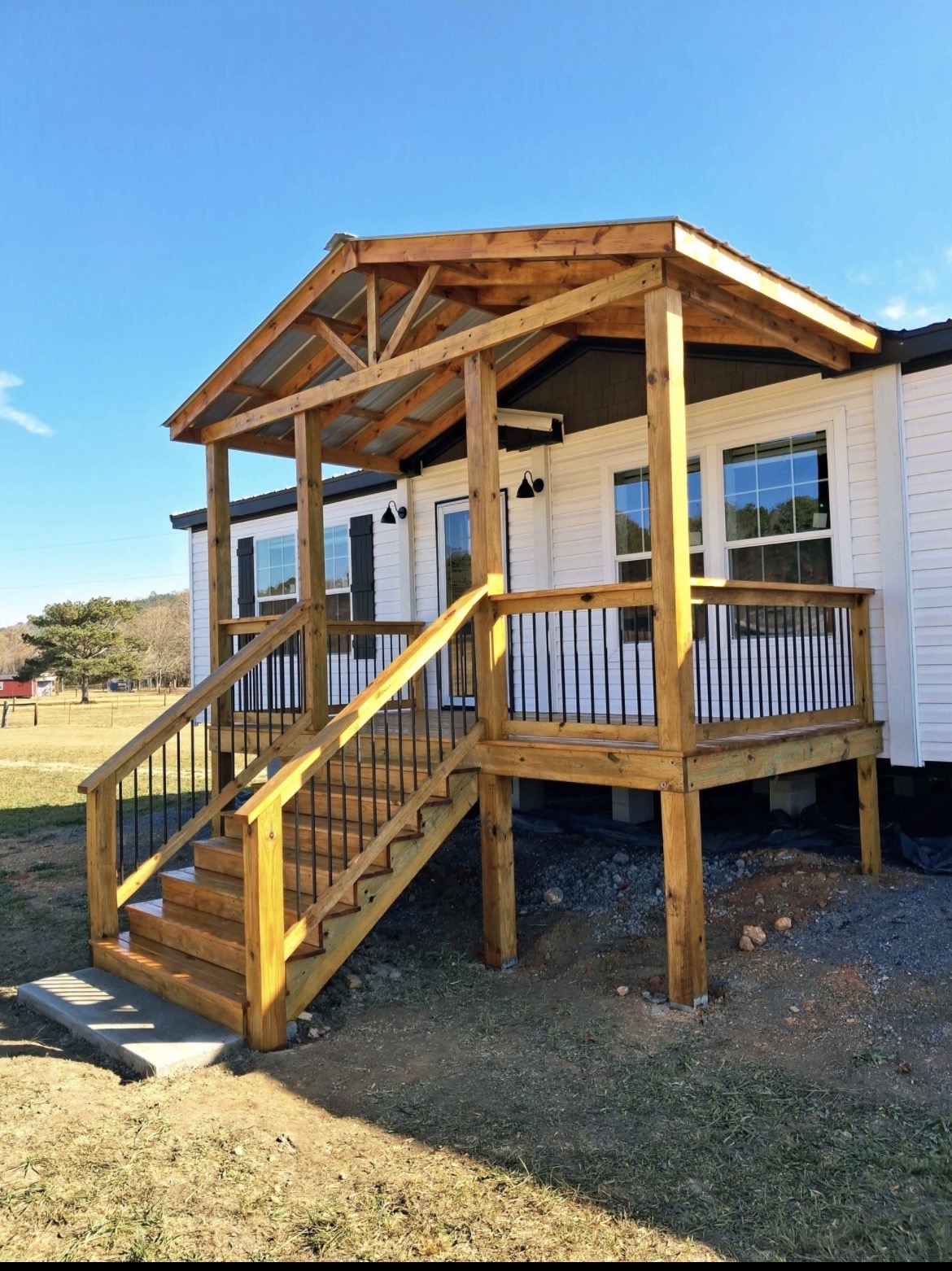 Covered porch with a timber gable roof, black metal balusters and wide front steps